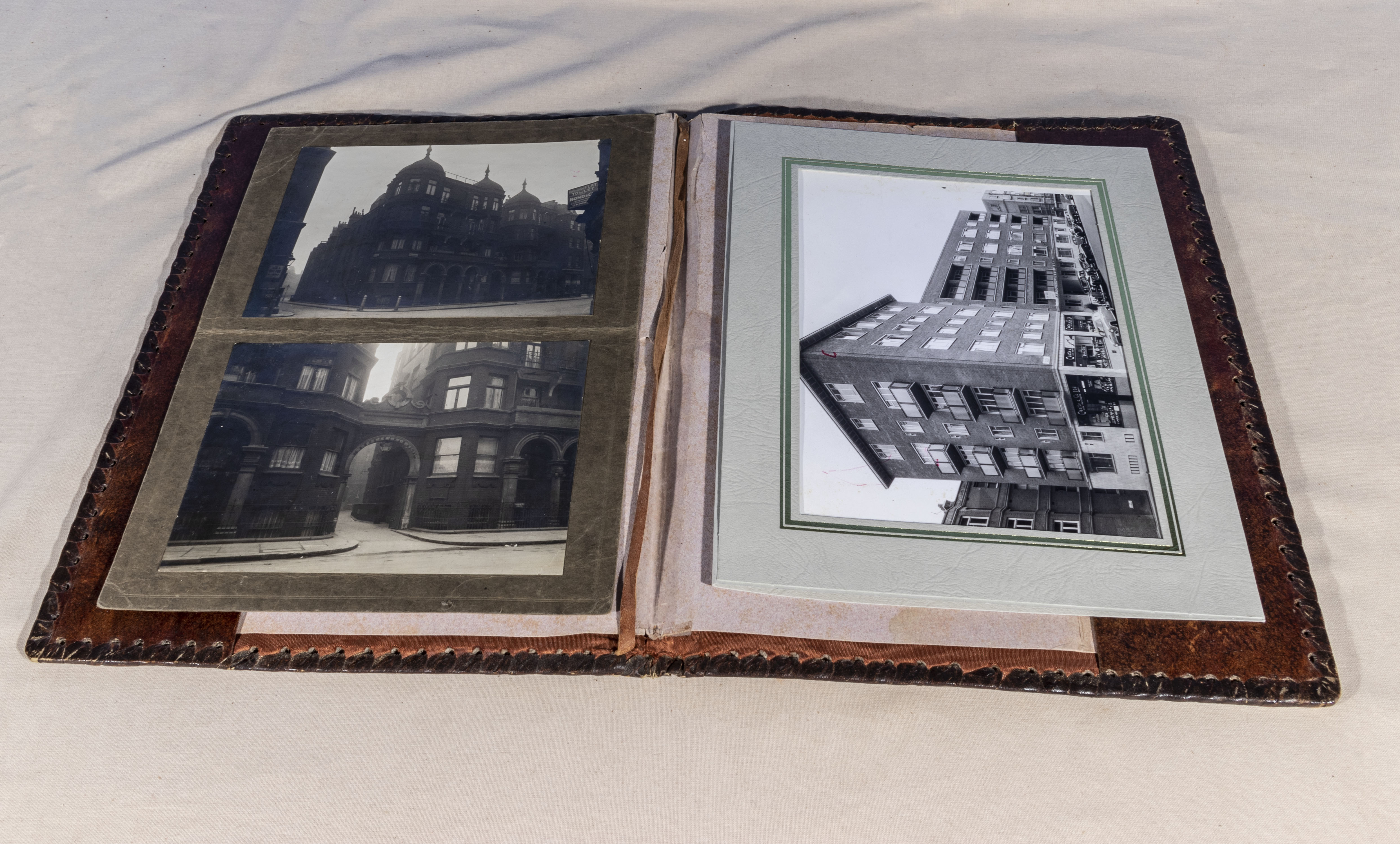 A tooled leather wallet containing photographs of 36 Buckinghamgate London SW1 pre and post war