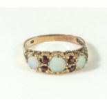 A 9ct gold ring set with three opals and garnets, 2gms