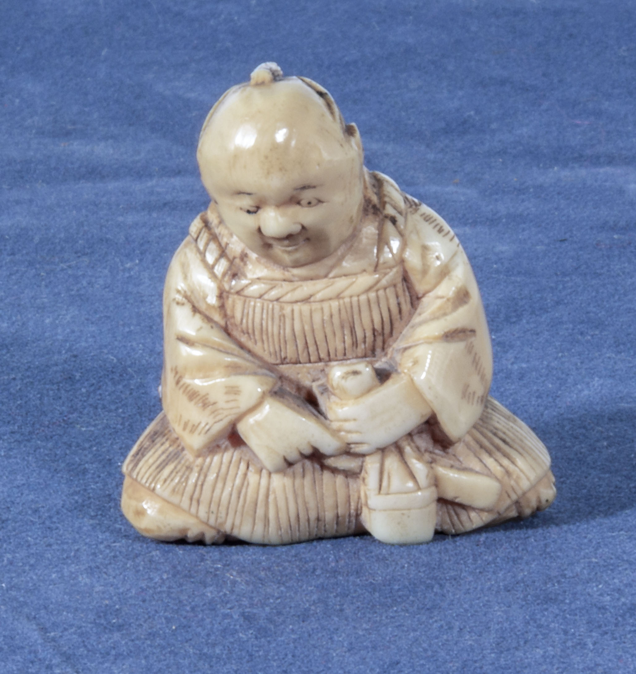 An antique netsuke of a seated man, 1.25"