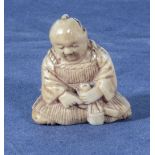 An antique netsuke of a seated man, 1.25"