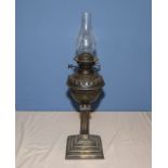 A brass and copper oil lamp, 48cm tall not including glass chimney