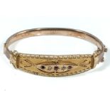 A Victorian 9ct gold bangle set with rubies and diamonds, 10.8gms (one ruby missing and shoulder)