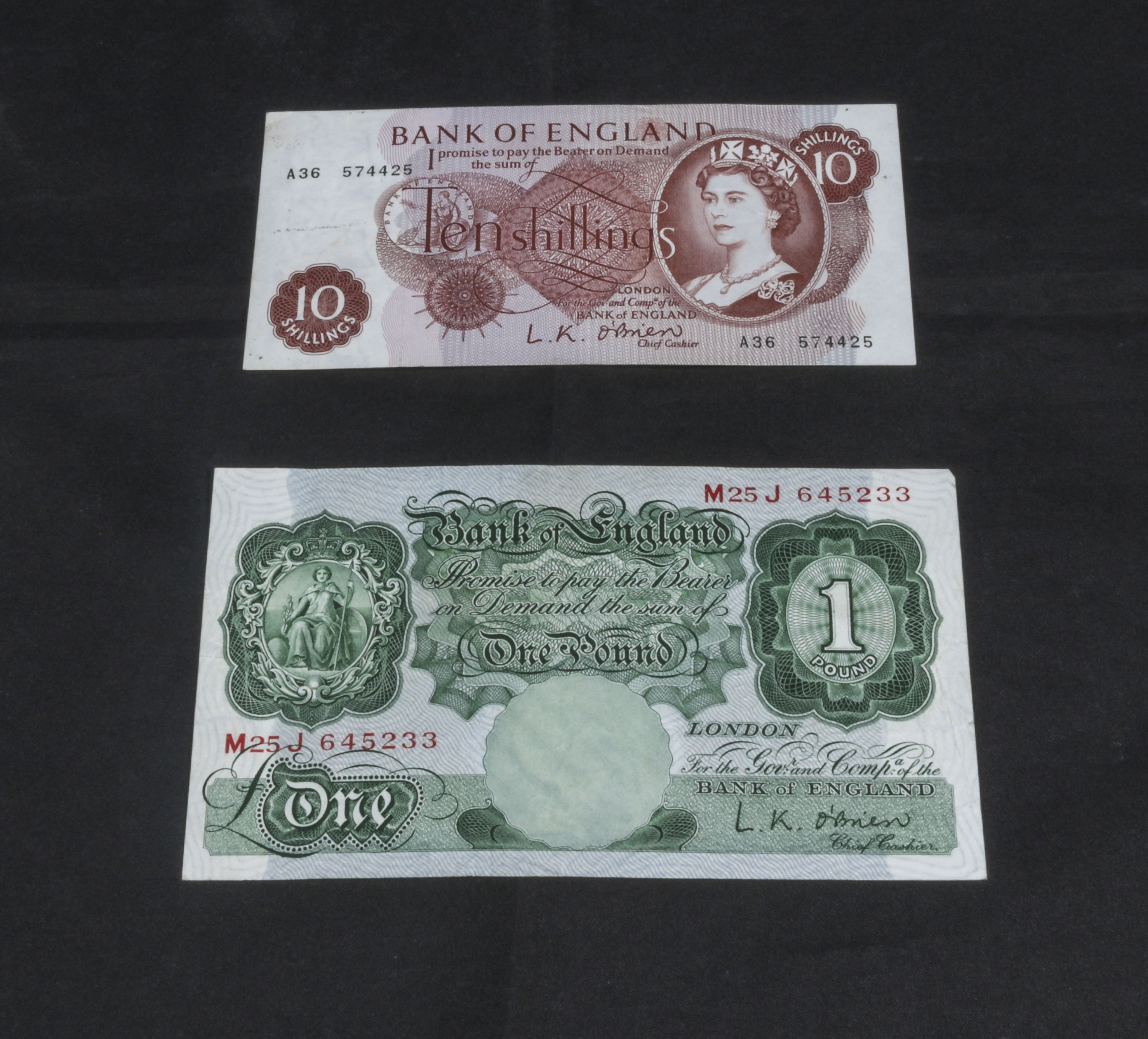 Bank of England 10 shillings brown paper note. Number A36.574425, with a green paper £1 note. O'