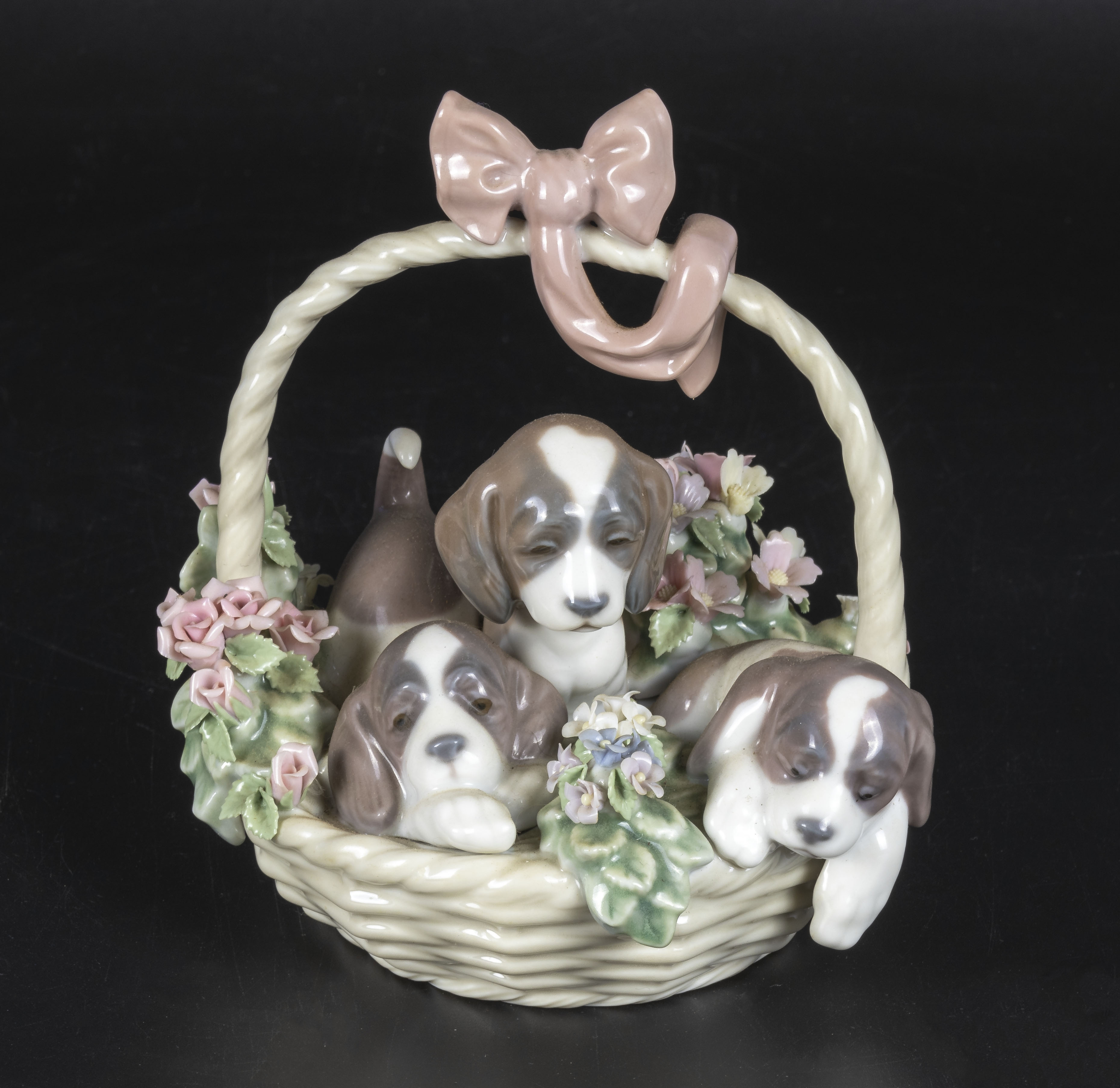 A Lladro figure group of a basket of puppies, 6" tall and 5" dia.
