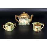 A cottage ware teapot, sugar and cream