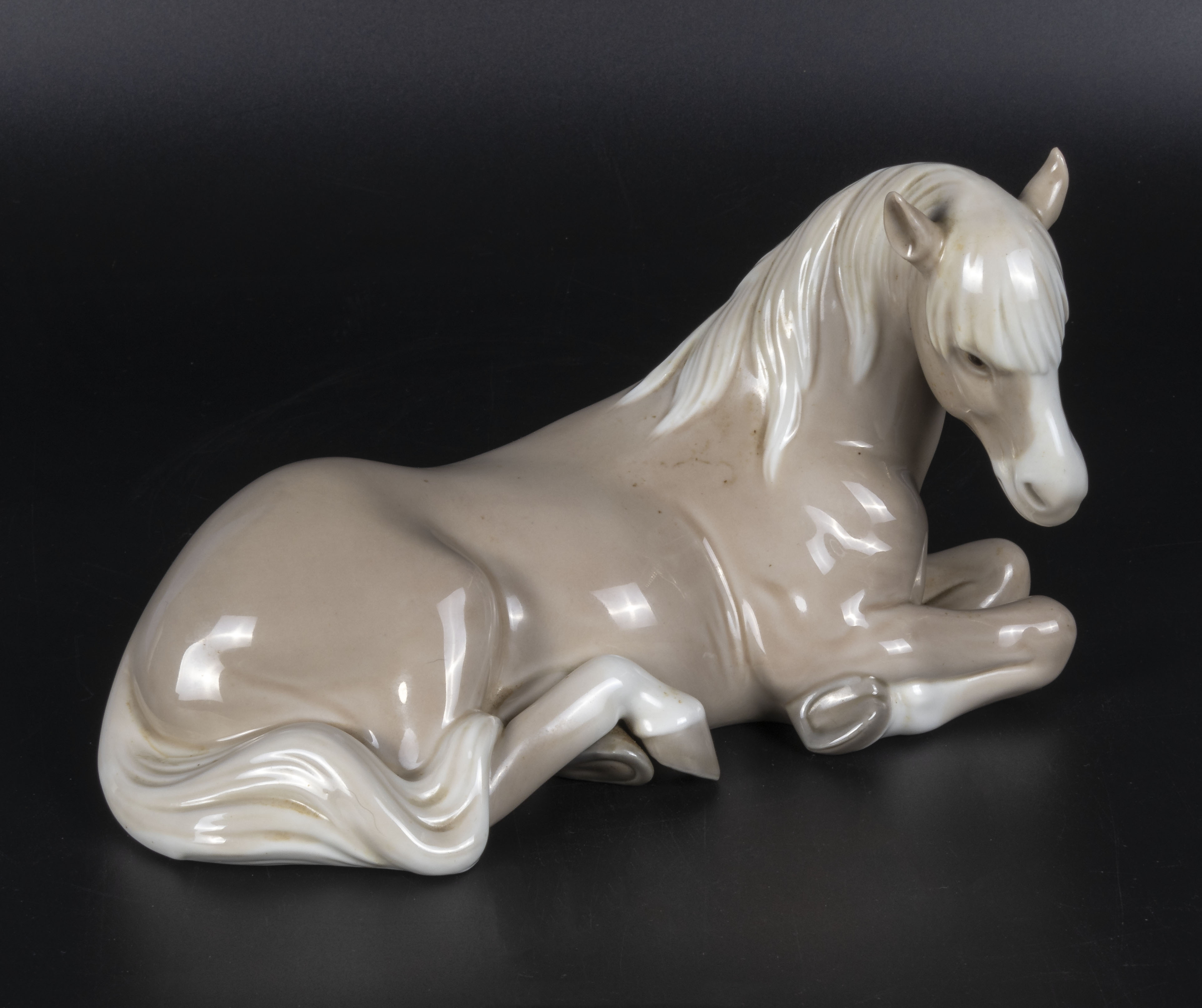 A Lladro figure of a recumbent horse, 8" in length