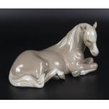 A Lladro figure of a recumbent horse, 8" in length