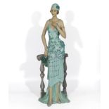 Large Art Deco style figure of an elegant lady of the period dressed in all refinery, leaning on a