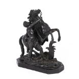 A small antique bronze of a man with a horse, with a fine patination on a black marble base, signed.