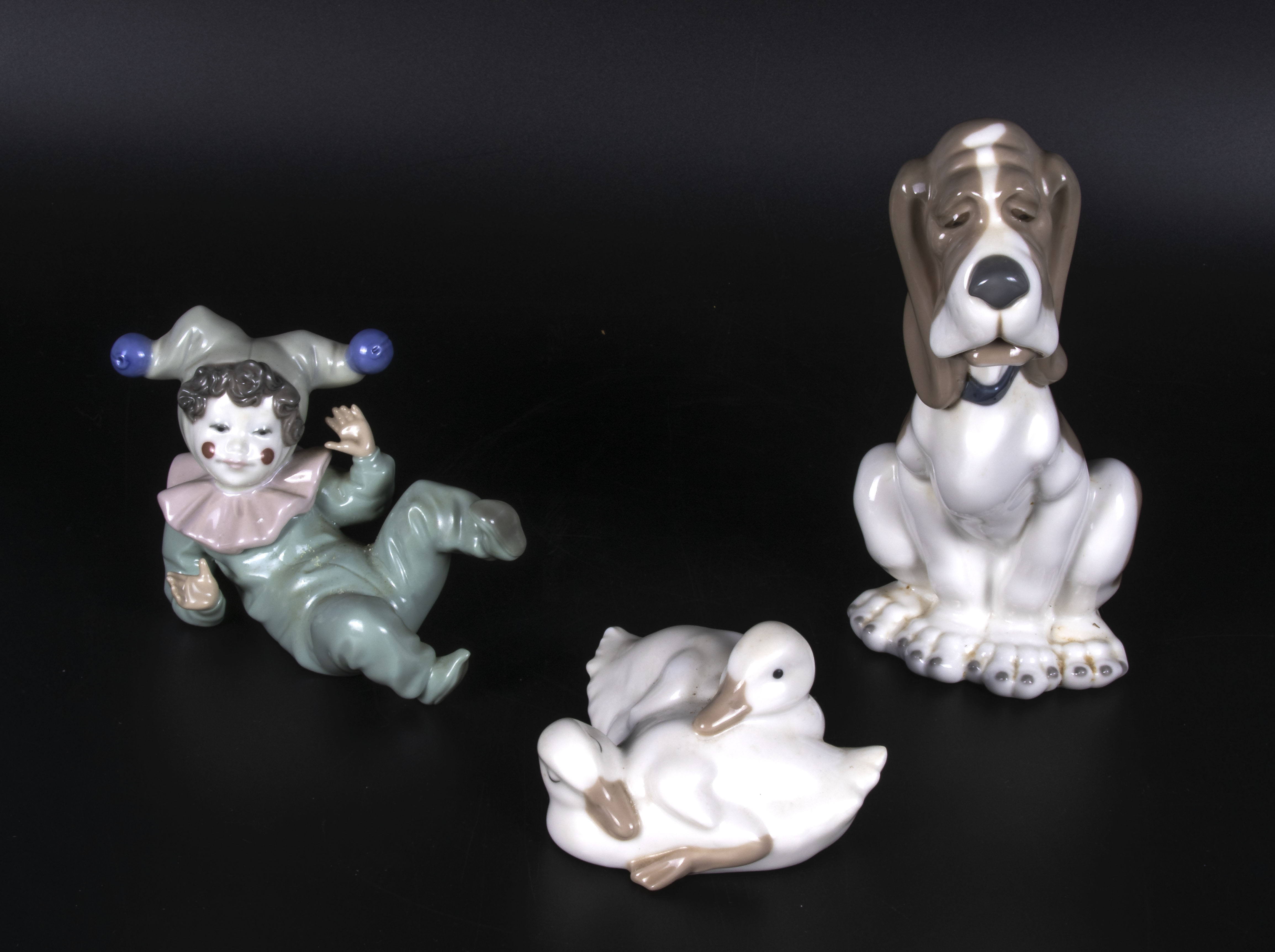 Three pieces of Nao porcelain, A dog 7" tall a duck and a clown