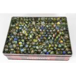 A tin box full of hundreds of vintage glass tri-coloured marbles