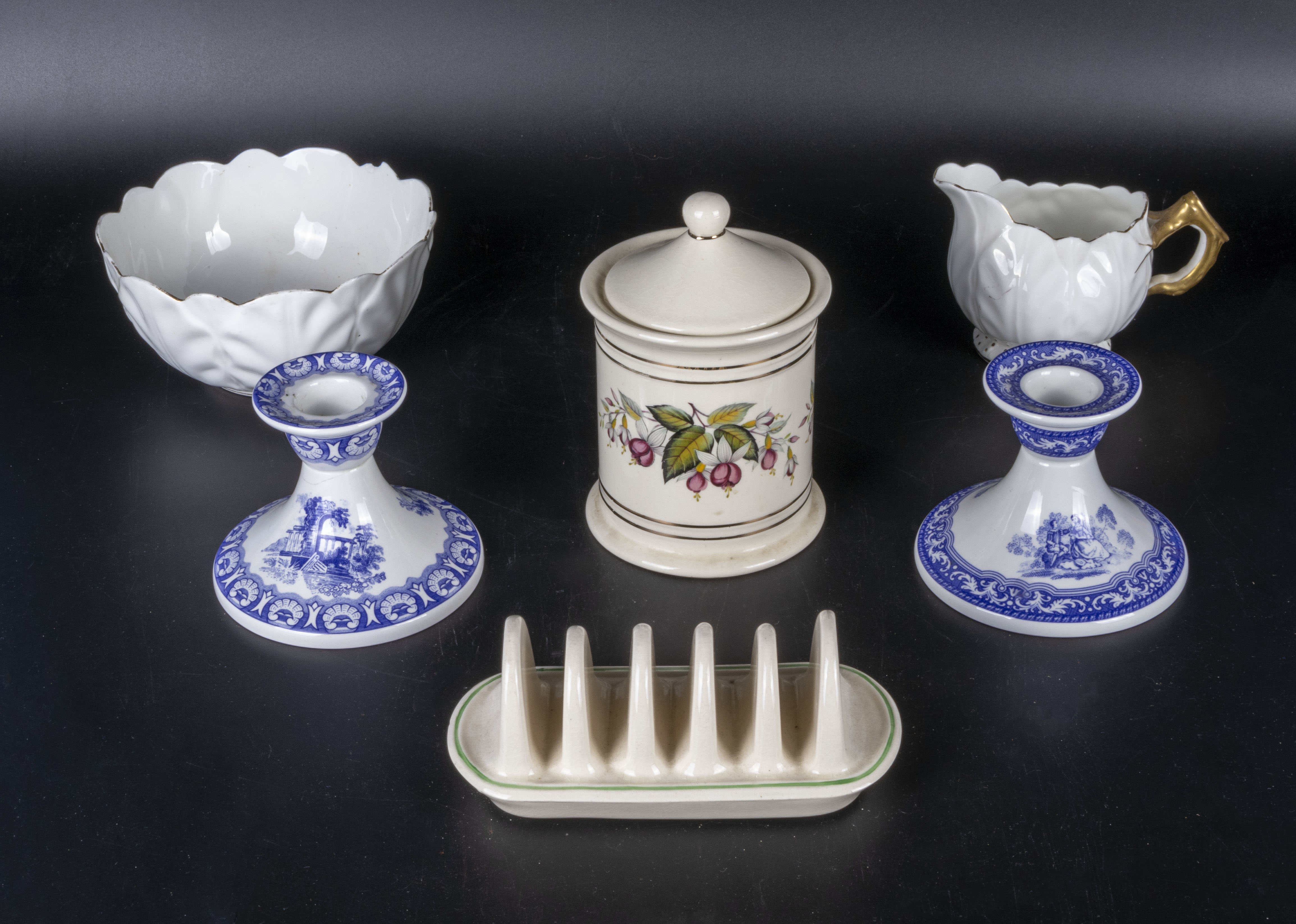 A pair of Spode blue and white candlesticks, a porcelain cream and sugar, lidded pot and a toast