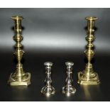 A pair of brass candlesticks together with a pair of small candlesticks