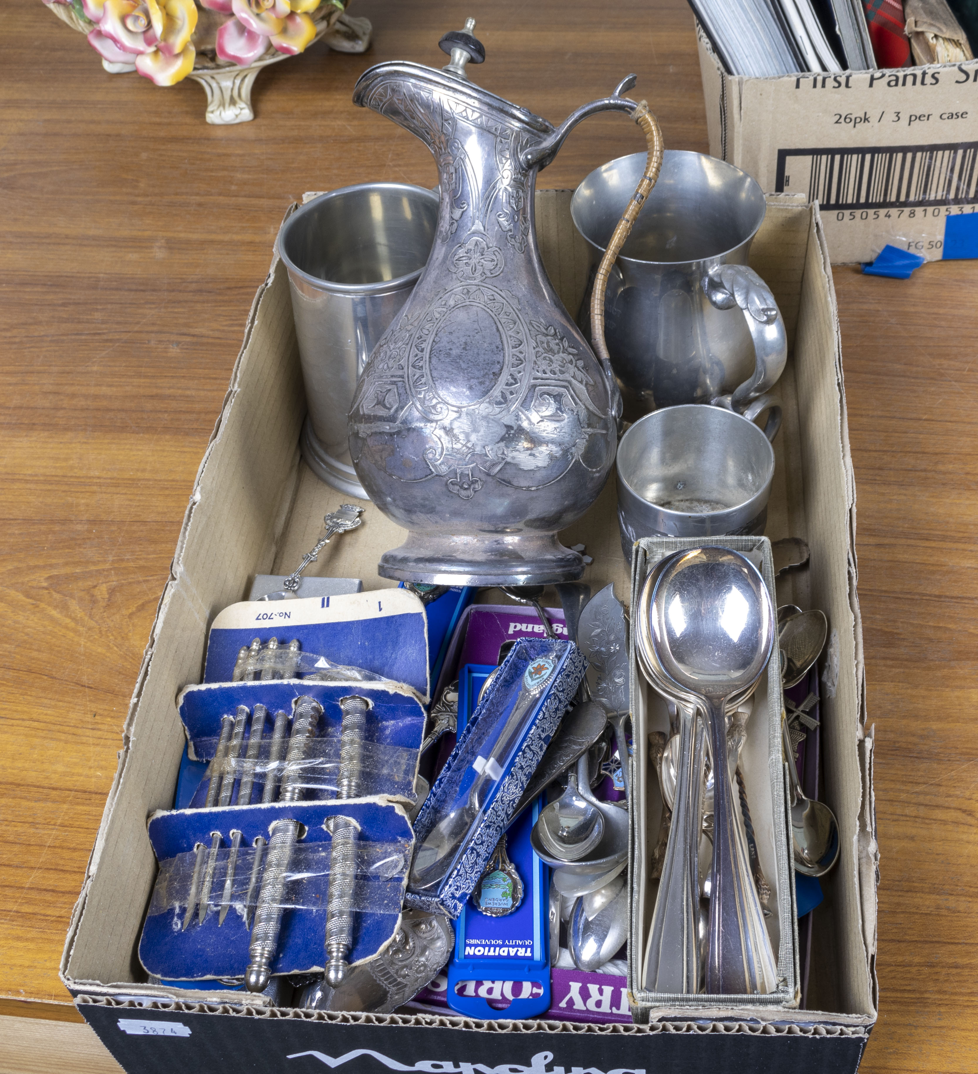 A box containing cutlery and pewter items