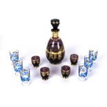 A gilt carafe with four shot glasses and six shot glasses