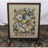 An oak framed embroidered fire screen