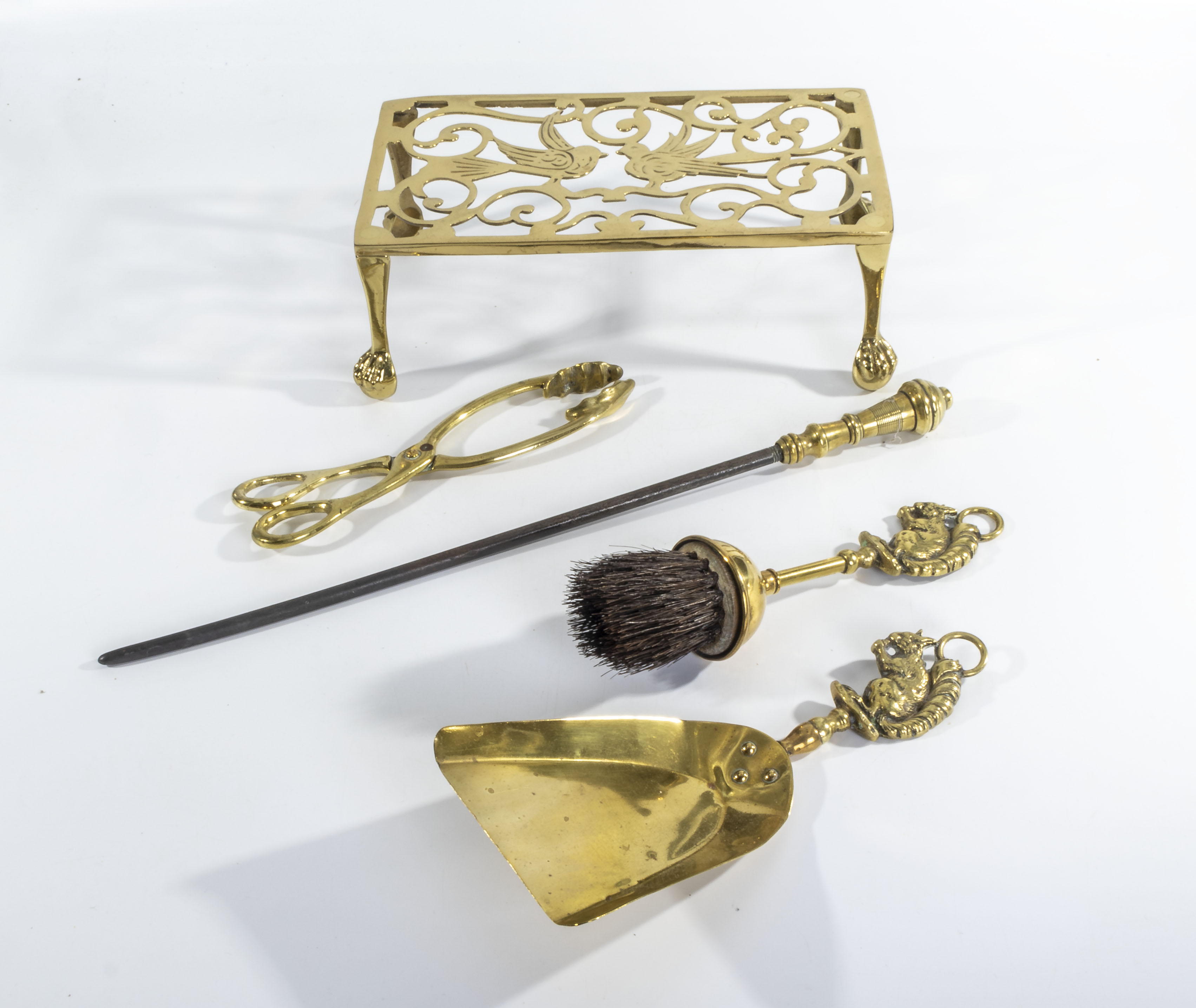 A brass trivet and fire irons