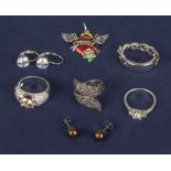 A collection of silver rings, earrings and a pendant