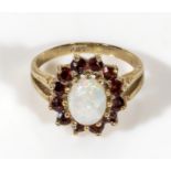 A ladys 9ct gold ring set with garnets and an opal, UK size L