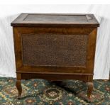 An oak bedding box with tooled leather inserts.