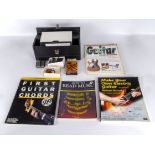 Four books relating to guitars and guitar playing together with a box containing guitar tuner,