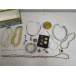 A selection of costume jewellery held in a domed top box to include a 1935 commemorative silver