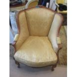 A reproduction French style armchair having floral crest rail and carved apron