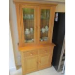 A modern light oak bookcase having twin glazed doors and drawers with cupboards below, 76 1/2"h x 40