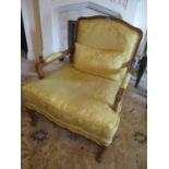A 20th century walnut French style armchair having floral upholstery and cabriole legs