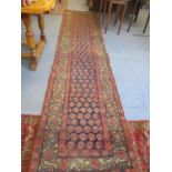 A Persian runner decorated with floral liphooks with triple guard border A/F
