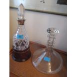 Glassware to include a ship's decanter, silver collared cut glass decanter and stopper in a stand