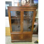 A reproduction bookcase having stepped cornice, crossbanded and herringbone inlay, twin glazed doors