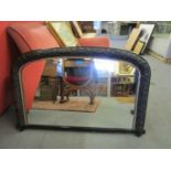 A late Victorian black painted gesso overmantle mirror