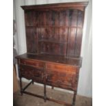 An early 20th century oak dresser having a plate rack above drawers and cupboards 74 3/4"h x 49 1/