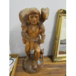 A 20th century carved wooden figure of a man carrying a sheep on his back, 29" h
