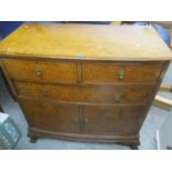 An early 20th century burr walnut veneered chest of two short and one long drawer above two cupboard