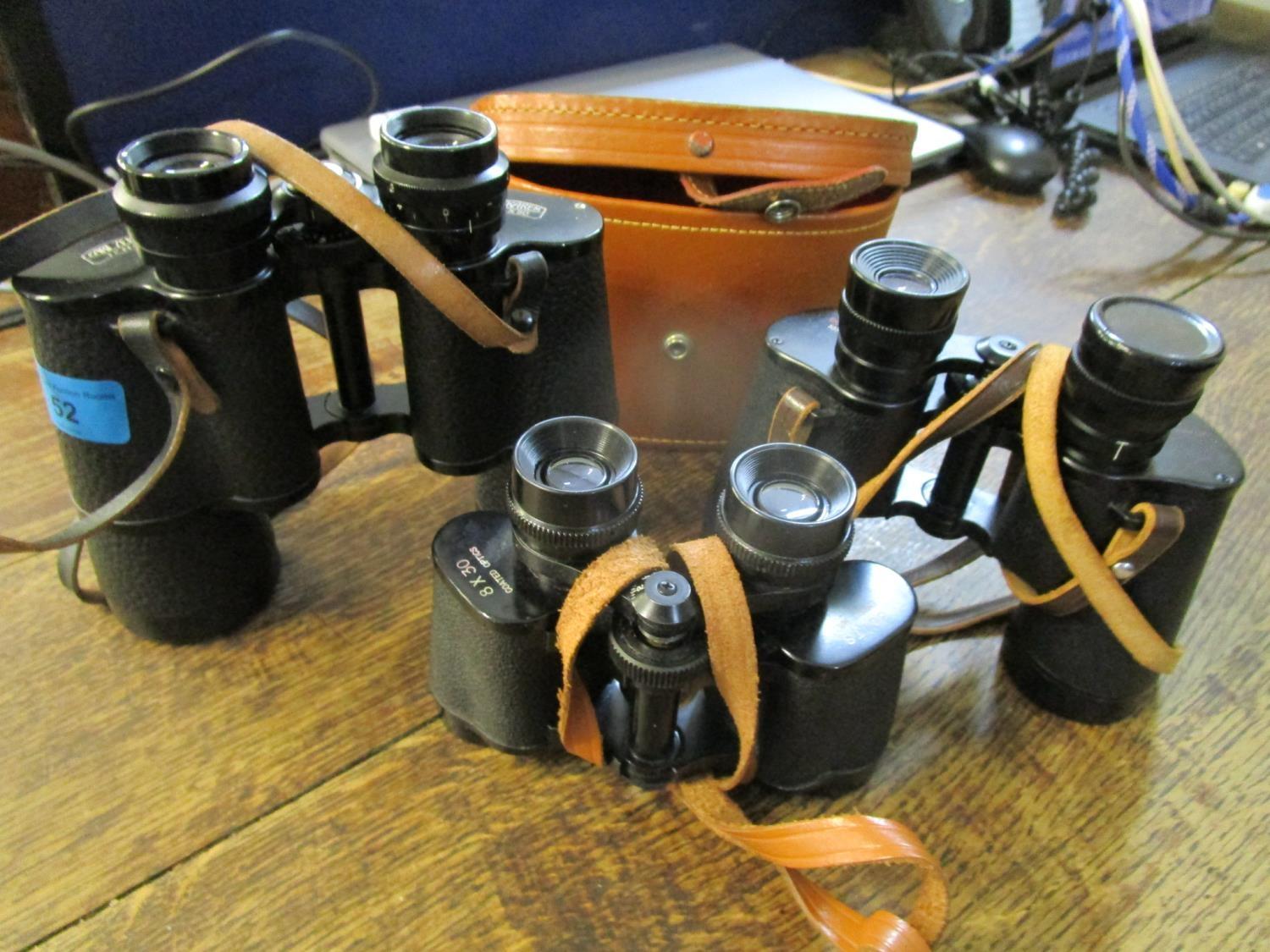 A group of three binoculars to include a Boots empire made 8 x 30 example