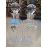 A pair of silver coloured and cut glass decanters with labels