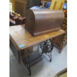 An early 20th century oak sewing machine table with attached sewing machine