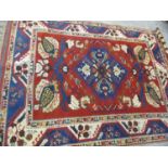 A Turkish woollen rug in red, navy and cream