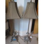 A pair of modern silver coloured table lamps standing on claw feet