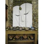 A collection of singing bowls of various sizes and a three-section wall plaque of an Asian face