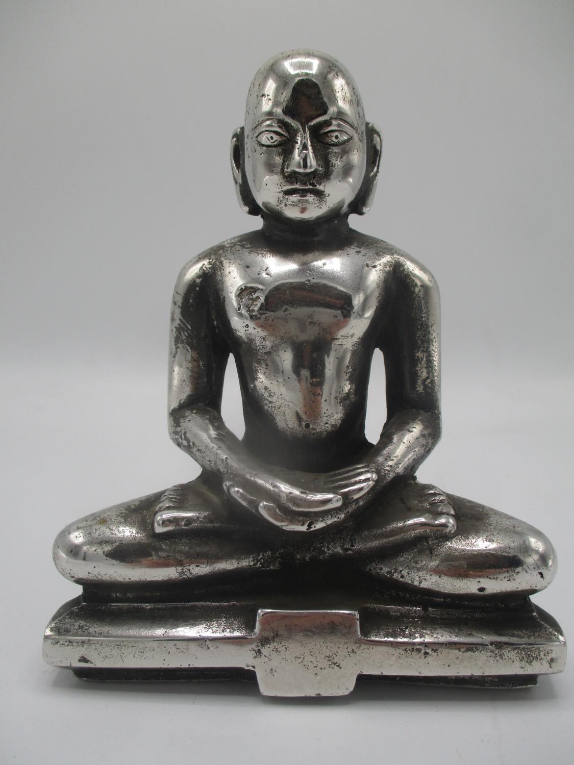 A Tibetan silver coloured figure of a Buddha on a plinth, 6" h