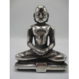 A Tibetan silver coloured figure of a Buddha on a plinth, 6" h