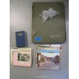 An Edwardian postcard album with a selection of postcards, and a small group of loose postcards