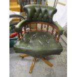 A reproduction green leather upholstered Captains swivel desk chair
