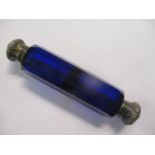 A Victorian blue glass facet cut double ended scent bottle having embossed silver caps 5 1/8" long