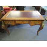 A reproduction Louis XV style walnut desk with a black scriber and three drawers on cabriole legs