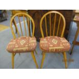 A pair of beech and elm Ercol style spindle back chairs