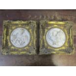 Two variegated reconstituted marble wall plaques of circular form, each depicting children in high